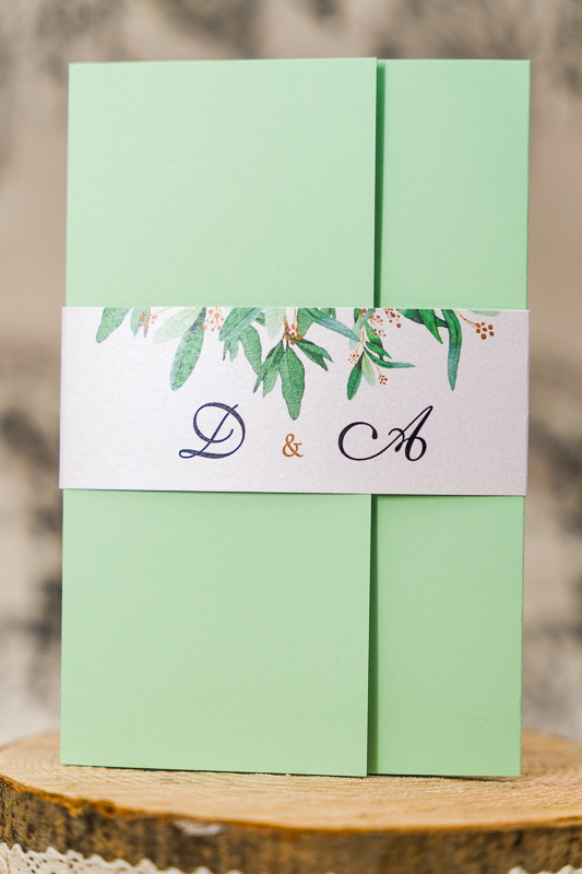 Zaproszenia ślubne kopertowe - jasny zielony papier z opaską z zielonymi listkami