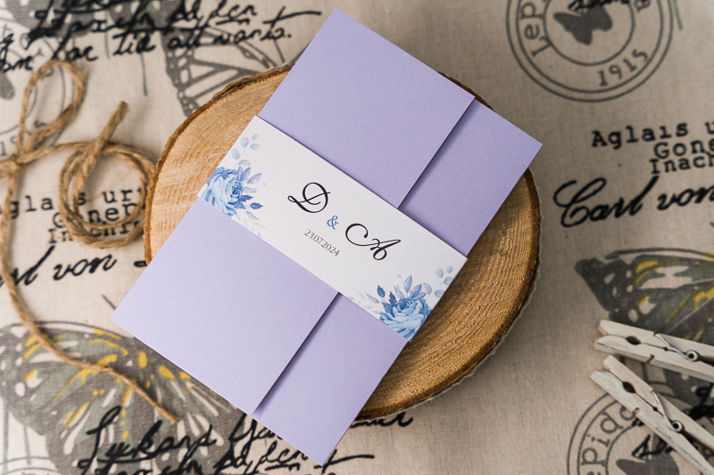 Zaproszenia ślubne jak koperta - jasny fioletowy papier z opaską z niebieskimi różami